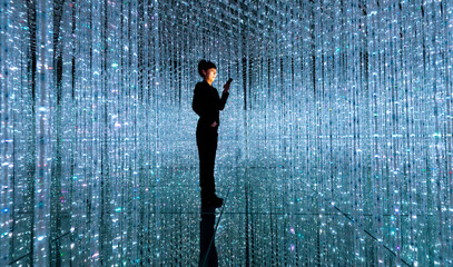 Businesswoman holding smart phone in the beautiful bokeh light