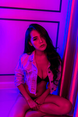 Portrait of beautiful sexy asian woman with neon light in the bedroom,Thailand people