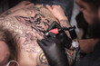 © Mr. Prof - Master of the art of tattooing working on professional tattoo machine gun in the salon