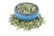 Small blue bowl with tea and dry thyme leaves on a white background.