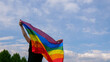 © OksanaFedorchuk - LGBT flag against blue sky with clouds on a sunny day and Celebrate Bisexuality Day or National Coming Out Day