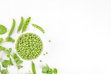 Fresh organic raw green peas in a bowl with peas pods and plants leaves on white background. Healthy eating, vegan and vegetarian legume food, raw food and detox super food, bean protein, top view