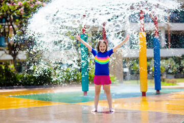 Wall Mural - Child playing under tip bucket in water park.