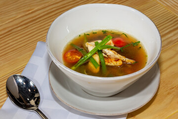 Wall Mural - Chicken soup with vegetables in white bowl. Grey stone background.