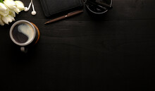 Cup Of Coffee, Notebook, Earphone And Tulips On Black Wooden Table. Flat Lay, Copy Space.