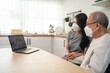 © Kawee - Asian senior male and daughter video call with doctor during pandemic.