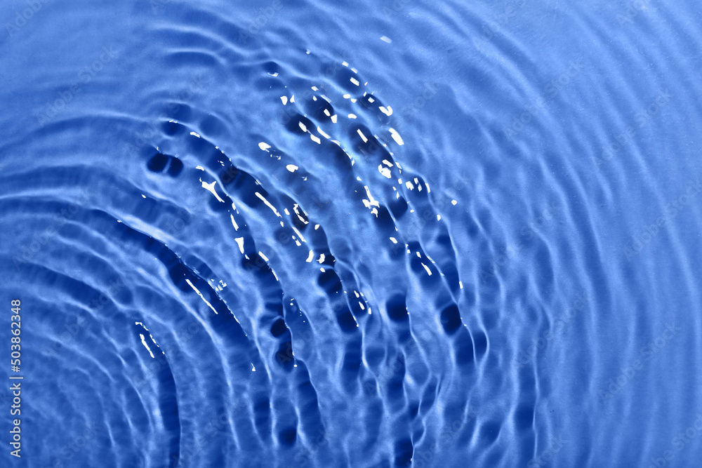 Clean water with splashes on color background