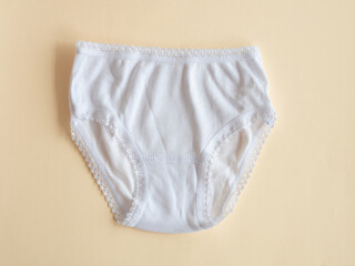 Underwear for children. White panties for girls on beige, knitted cotton underwear. Underwear for children