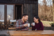 Happy Lovers Smiling And Looking At Each Other While Drinking Coffee And Enjoying The Outdoor.