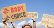 Protesters holding signs My Body My Choice, Abortion Is Healthcare, Human right. People with placards supporting abortion rights at protest rally demonstration.