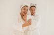 © Look! - Young caucasian women during spa procedures are photographed looking at camera on white background. Blondes wear bathrobes, hair bands and eye patches. Beauty needs care concept