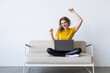 © F8  \ Suport Ukraine - Young woman with credit card and laptop sitting on sofa at home