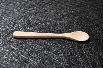 Wall Mural - an empty wooden spoon on a dark background