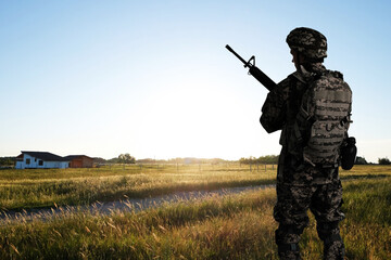 Wall Mural - Soldier with machine gun outdoors, back view