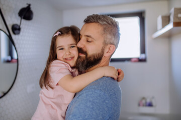 Wall Mural - Happy father hugging his little daughter in bathroom.