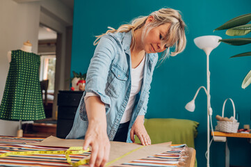 Woman tailor working from home and tailoring beautiful clothes