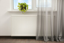 Beautiful Houseplant On Window Sill And Modern Radiator At Home. Central Heating System