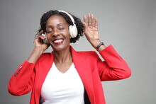 Smiling Businesswoman Listening To Music On Headphones