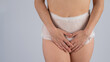 A woman in adult diapers holds her hands on her stomach. Urinary incontinence problem.