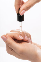 Female Hands And Bottle Of Nourishing Cuticle Oil With A Dropper