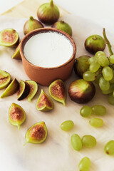 Wall Mural - Delicious natural Greek yogurt in clay bowl with figs and grape