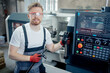© Parilov - Engineer man work on CNC machine at automatic factory floor. Concept modern industry process metal detail production