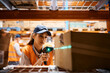 © Drazen - Female warehouse worker uses bar code reader while scanning packages at storage compartment.