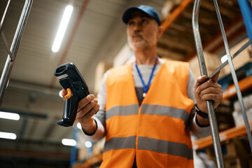 Poster - Close up of warehouse worker scanning packages in storage room.