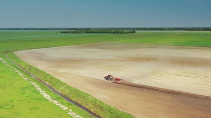 Wall Mural - 4K Aerial View. Tractor With Seed Drill Machine Sowing The Seeds For Crops In Spring Season. Beginning Of Agricultural Spring Season. Countryside Field Landscape. Cinematic Shot.