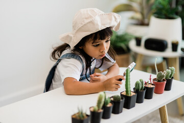 Asian little girl is planting plants in the house, concept of plant growing learning activity for a preschool kid and child education for the tree in nature