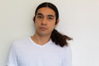 © Antonio Tanaka - portrait of a non binary hispanic man with long hair on a white background