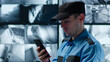 © nimito - Male officer using smartphone working in security monitoring center