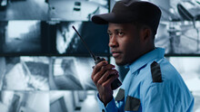 Side View Of African-American Security Guard Talk On Radio In Control Room
