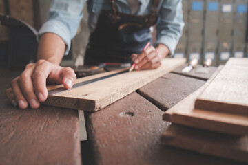 Carpenter working with equipment on wooden table in carpentry shop. woman works in a carpentry shop.