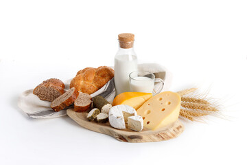 Jewish holiday Shavuot concept with dairy products, cheese, bread, milk bottle on white background