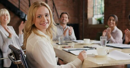 Aufkleber - a young businesswoman having a meeting with her colleagues in a modern office. A smiling young businesswoman in a meeting with her coworkers clapping and celebrating her success.