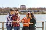 Fototapeta Londyn - lesbian couple and gay couple having fun on a floating jetty