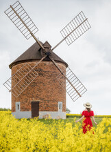 Girl In Front Of An Old Windmill In The Countryside