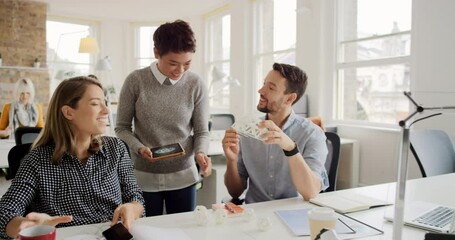 Wall Mural - A group of young businesspeople brainstorming, thinking about ideas for a 3D dome model. Corporate businesspeople smiling, talking during meeting using a wireless digital tablet device.