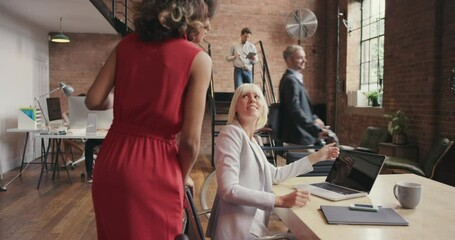 Aufkleber - A businesswoman helping a group of diverse team members in her office. Happy businesswoman walking through her office talking to staff. Young Hispanic boss collaborating with colleagues in the office