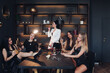 Group of fashion young sexy woman enjoying playing poker and drinking champagne