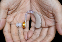 Electronic Hearing Aid Device In The Ear Of Asian Old Man With Total Deafness.