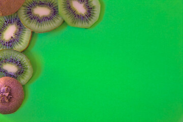 Wall Mural - kiwi fruit on a green colored background