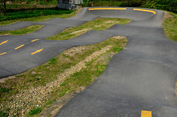 Wall Mural - bike path in the car park Pumping (moving up and down) is used instead of pedaling and bouncing to move bicycles, scooters, skateboards and inline skates along the modular pumptrack track