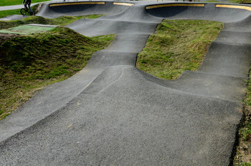 Wall Mural - bike path in the car park Pumping (moving up and down) is used instead of pedaling and bouncing to move bicycles, scooters, skateboards and inline skates along the modular pumptrack track