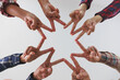 © Tinnakorn - A diverse group of people connects their hands as a supportive sign expressing a sense of teamwork. Unity and togetherness.