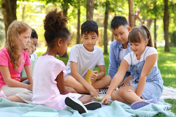 Canvas Print - Little pupils reading book in park