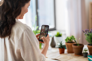 Poster - people, gardening and housework concept - happy woman with smartphone photographing pot flowers at home