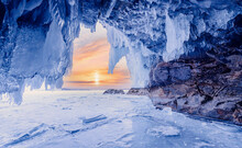 Blue Ice Cave Grotto Lake Baikal Sunset. Frozen Clear Icicles, Beautiful Winter Landscape
