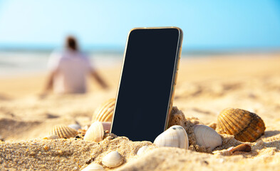 mobile phone on the beach and silhouette people relaxing